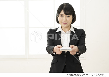 年輕女子穿著西裝展示名片(正面) 年輕女子穿著西裝展示名片(正面) 76522950