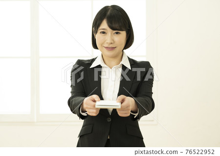 年輕女子穿著西裝展示名片(正面) 年輕女子穿著西裝展示名片(正面) 76522952