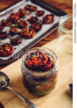 Preserving of Sun Dried Tomatoes with Thyme in a Jar 76522980