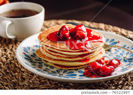 Stack of pancakes with cornelian cherry jam on plate 76522997