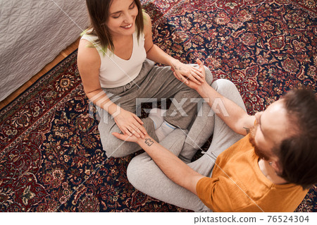 Delighted couple being in the bedroom and meditating together 76524304