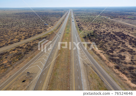 Aerial view of long road through desert landscape towards near San Jon New Mexico USA Aerial view of long road through desert landscape towards near San Jon New Mexico USA 76524646