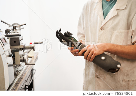Man holding bionic hand while developing prothesis artificial limbs 76524801