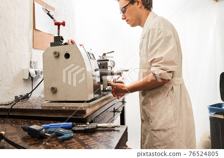 Man engineer standing at the special machine and working while developing Man engineer standing at the special machine and working while developing 76524805