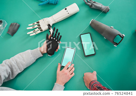 People holding plastic hand and looking something at the smartphone 76524841