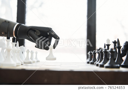 Engineer making move with black bionic hand while playing at the chess 76524853