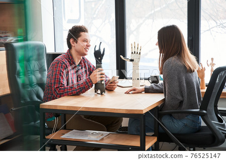 Male engineer sitting with his female colleague 76525147