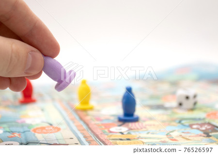 Hand throwing the play figure on the board game playing field Hand throwing the play figure on the board game playing field 76526597