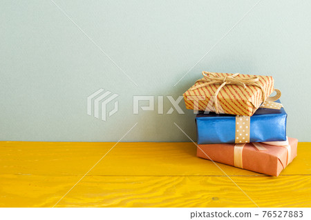 Gift boxes on wooden table. blue background 76527883
