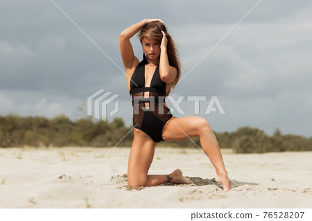 Gorgeous young female crawling on beach 76528207