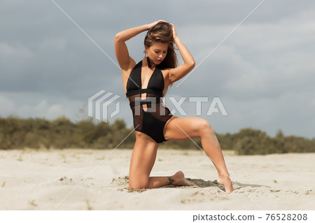 Gorgeous young female crawling on beach Gorgeous young female crawling on beach 76528208