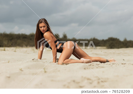Gorgeous young female crawling on beach Gorgeous young female crawling on beach 76528209