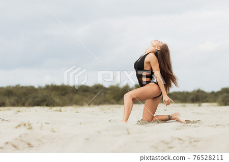 Gorgeous young female crawling on beach Gorgeous young female crawling on beach 76528211