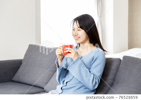 放鬆在沙發的一個少婦 76528859