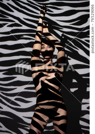 Fashion portrait of young lady with shadow on her body 76529066