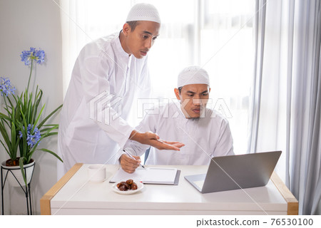 muslim business partner discussing and meeting using laptop 76530100