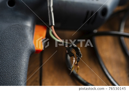 Burning wires on parts of an electrical appliance in a repair shop. Power tool repair Burning wires on parts of an electrical appliance in a repair shop. Power tool repair 76530145