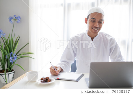 muslim businessman working using laptop while sitting on the desk 76530157