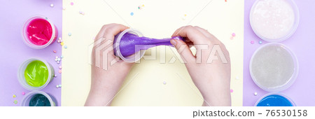 Multi-colored slimes on the table. The child plays with slimes. Play toy - slime 76530158