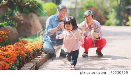 couple play with granddaughter 76530769