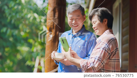 retired couple watching smartphone retired couple watching smartphone 76530775