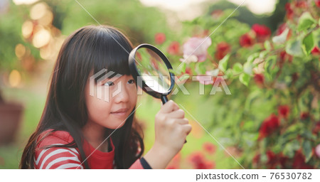 Asian girl use magnifer Asian girl use magnifer 76530782