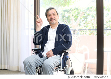 坐在輪椅上的微笑老人用食指 76530843