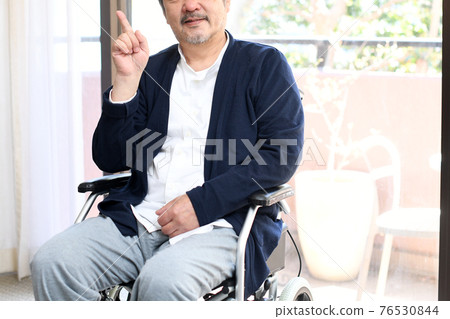 坐在輪椅上的微笑老人用食指 坐在輪椅上的微笑老人用食指 76530844