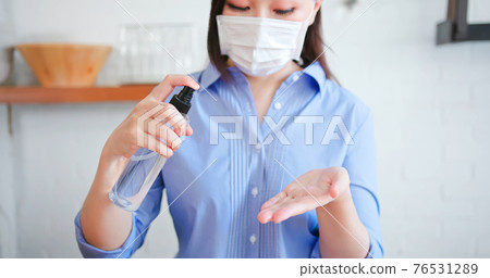 wipes hands with alcohol spray 76531289