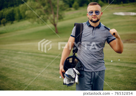 Handsome man playing golf on a golf course 76532854