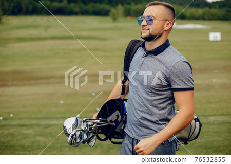Handsome man playing golf on a golf course 76532855