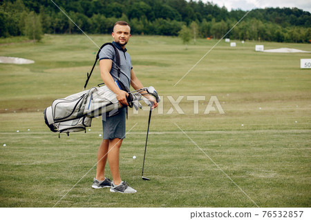 Handsome man playing golf on a golf course 76532857