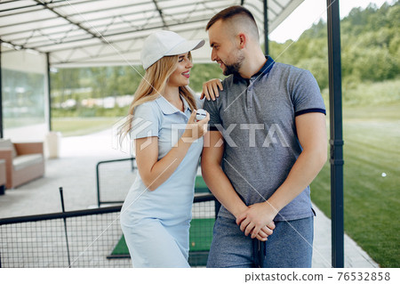 Beautiful couple playing golf on a golf course Beautiful couple playing golf on a golf course 76532858
