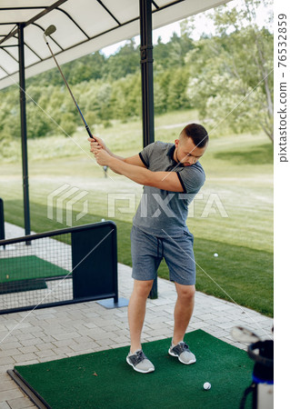 Handsome man playing golf on a golf course 76532859