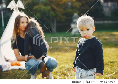 Mother with children playing in a summer park 76532892