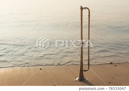 wind instrument tube stands on the seashore, sunrise beautiful lighting, the concept of music 76533047