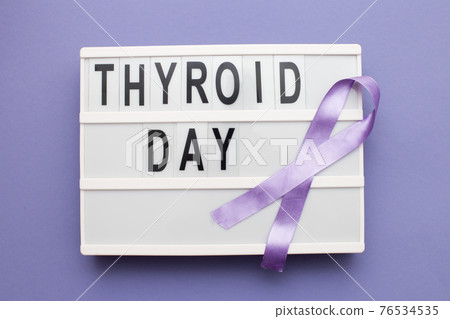 inscription international thyroid day and violet ribbon on purple background inscription international thyroid day and violet ribbon on purple background 76534535