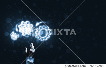 Glowing cogwheel mechanism icon on dark background as symbol of teamwork 76535288