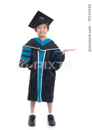 Cute Asian child in graduation gown show something copy space.Commercial advertisement. Promotion concept. Promoting product for kids. 76535448