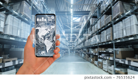 Hand with a phone on the background of a warehouse 76535624