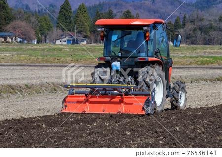 A man cultivating rice fields with a tractor Spring April 76536141