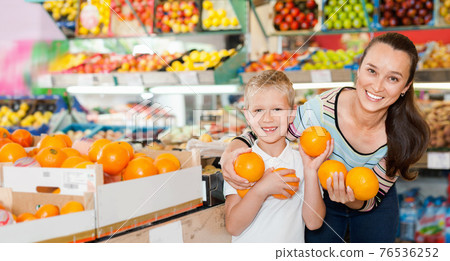 Portrait of happy woman and her little son choosing oranges at shop Portrait of happy woman and her little son choosing oranges at shop 76536252