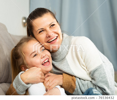 Happy family woman with small daughter laughing at home 76536432