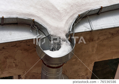 Frozen roof gutter clogged with snow and ice Frozen roof gutter clogged with snow and ice 76536586