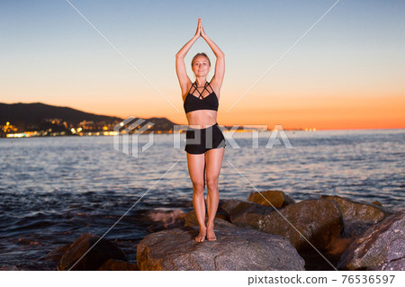 Adult woman is practicing stretching Adult woman is practicing stretching 76536597