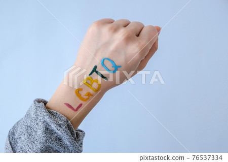 Rainbow LGBTQ flag painted on hand. Support for lgbt community. Honour of pride month. Connecting people, touching hands. Rainbow LGBTQ flag painted on hand. Support for lgbt community. Honour of pride month. Connecting people, touching hands. 76537334