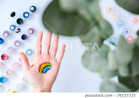Rainbow LGBTQ flag painted on hand. Support for lgbt community. Honour of pride month. Connecting people, touching hands. Rainbow LGBTQ flag painted on hand. Support for lgbt community. Honour of pride month. Connecting people, touching hands. 76537335