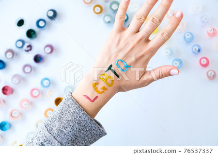 Rainbow LGBTQ flag painted on hand. Support for lgbt community. Honour of pride month. Connecting people, touching hands. Rainbow LGBTQ flag painted on hand. Support for lgbt community. Honour of pride month. Connecting people, touching hands. 76537337