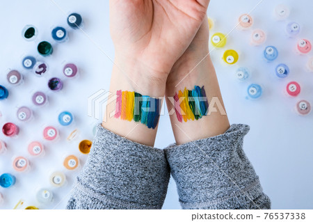 Rainbow LGBTQ flag painted on hand. Support for lgbt community. Honour of pride month. Connecting people, touching hands. 76537338