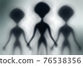Silhouettes of spooky aliens and bright light on behind them 76538356
